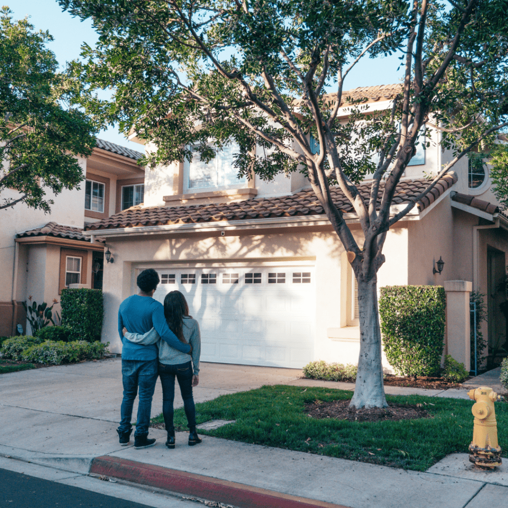 couple standing in front of their new house