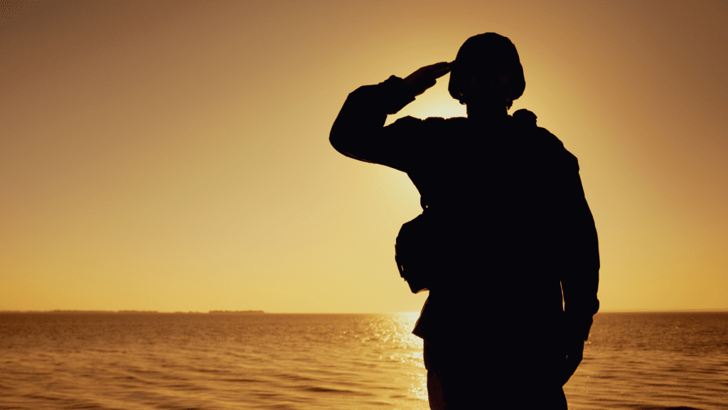 silhouette of soldier saluting with sunset